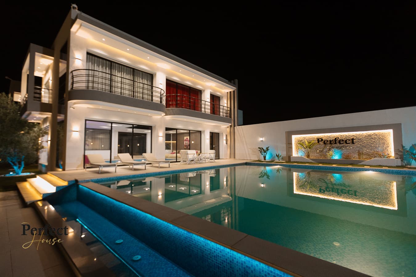 Night view of the illuminated villa and outdoor pool